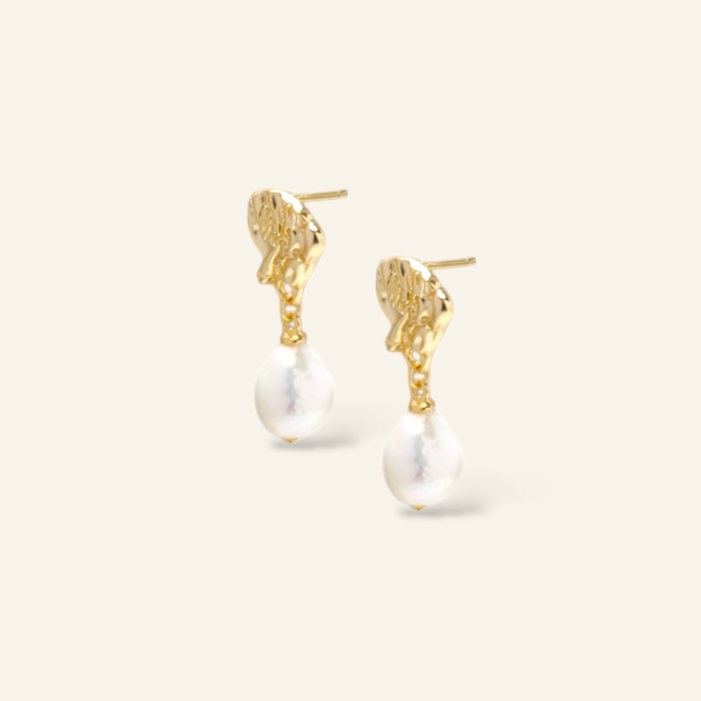 Gold earrings with pearl drops on a white background