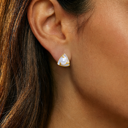 Close-up of an ear wearing a gold and pearl earring