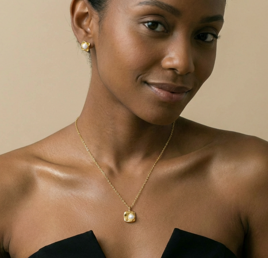 Woman wearing a gold necklace with a pearl pendant