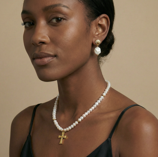 Woman wearing a pearl necklace and earrings against a beige background