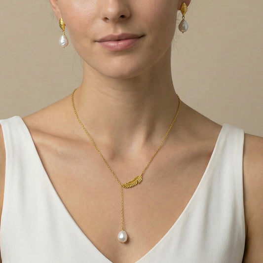 Woman wearing a gold necklace with a pearl pendant