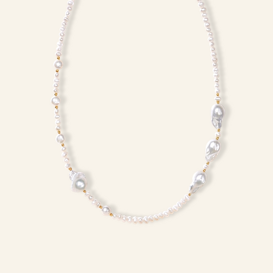 Pearl necklace with gold accents on a white background