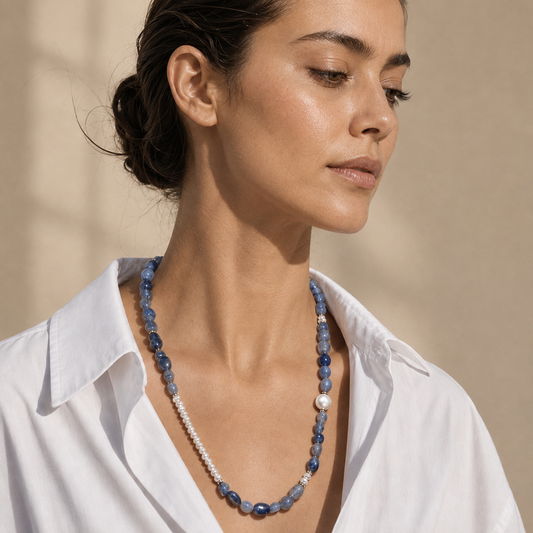 A close-up of a woman wearing a pearl necklace with Blue Aventurine