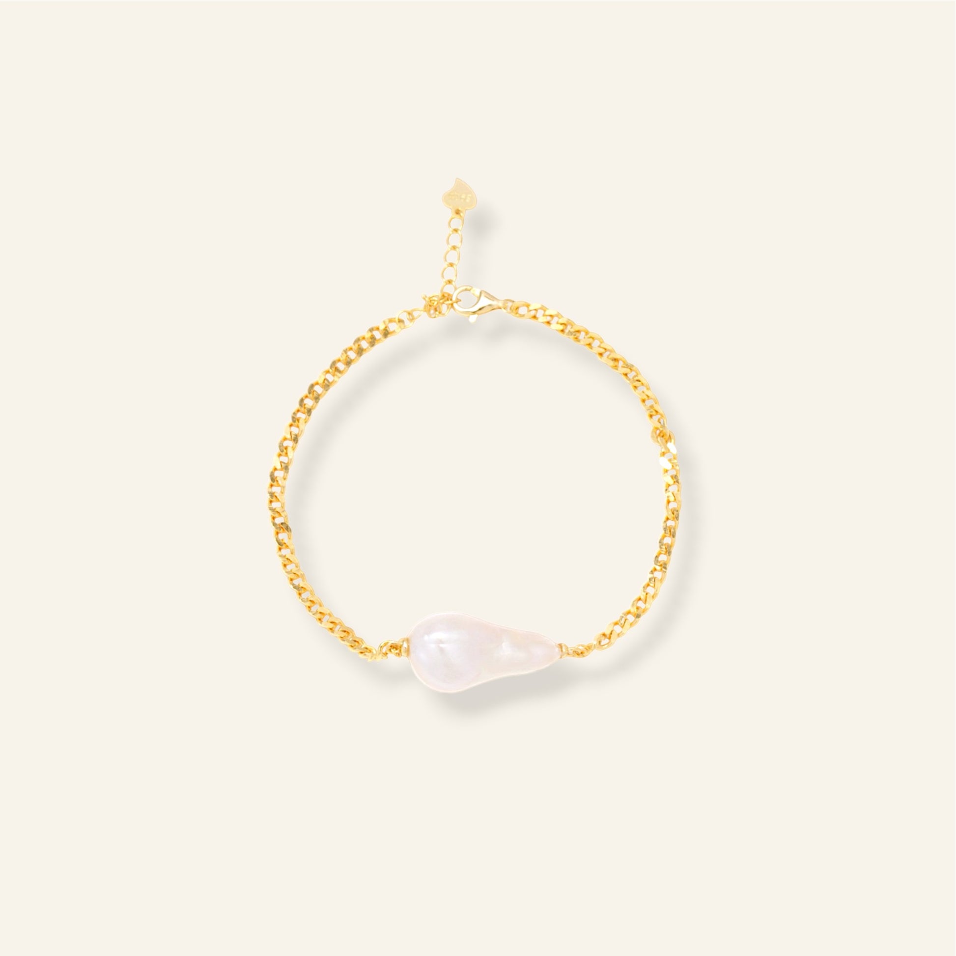 Gold bracelet with pearl on a light beige background