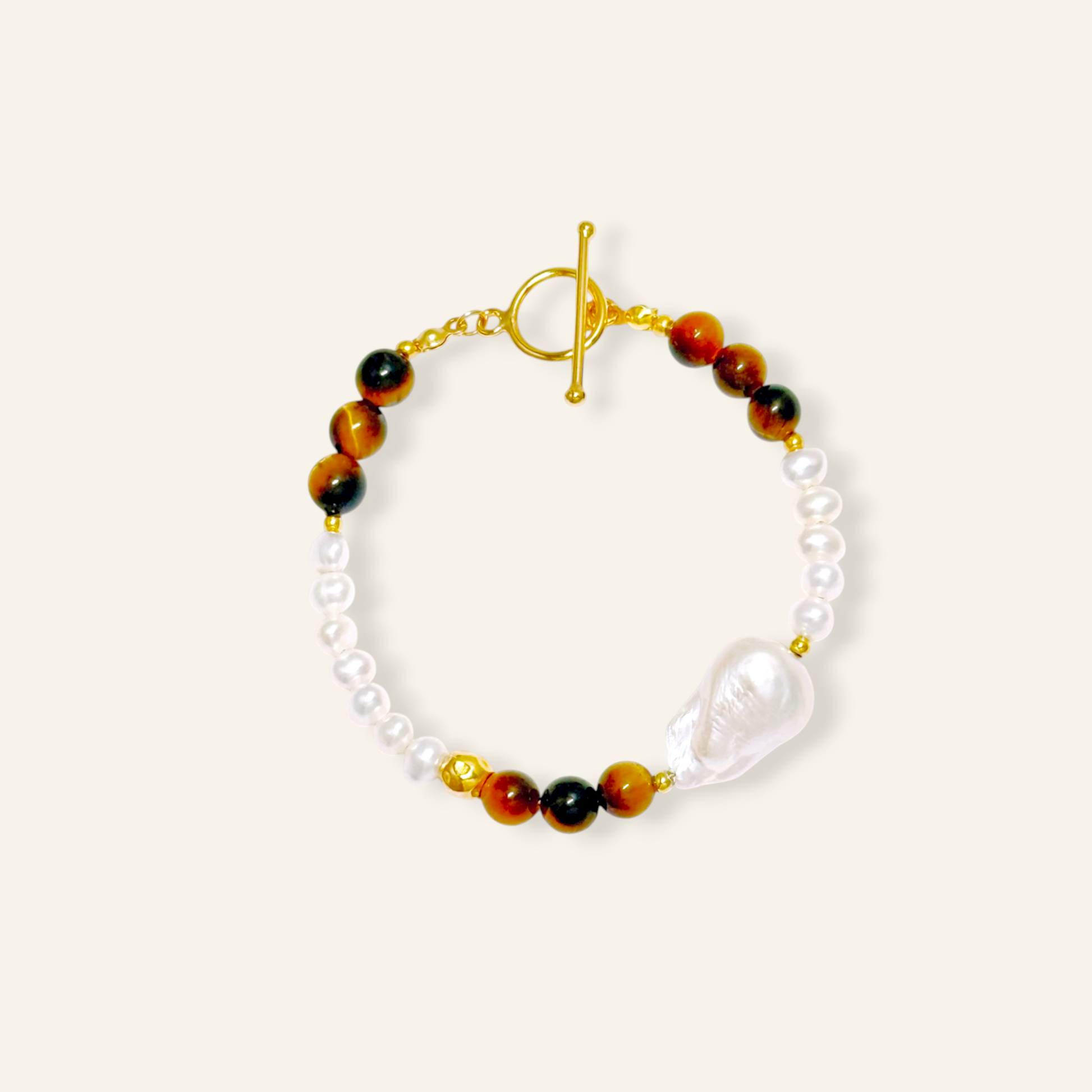 A beaded bracelet featuring white baroque pearls, brown and black tiger's eye beads, and a large baroque pearl