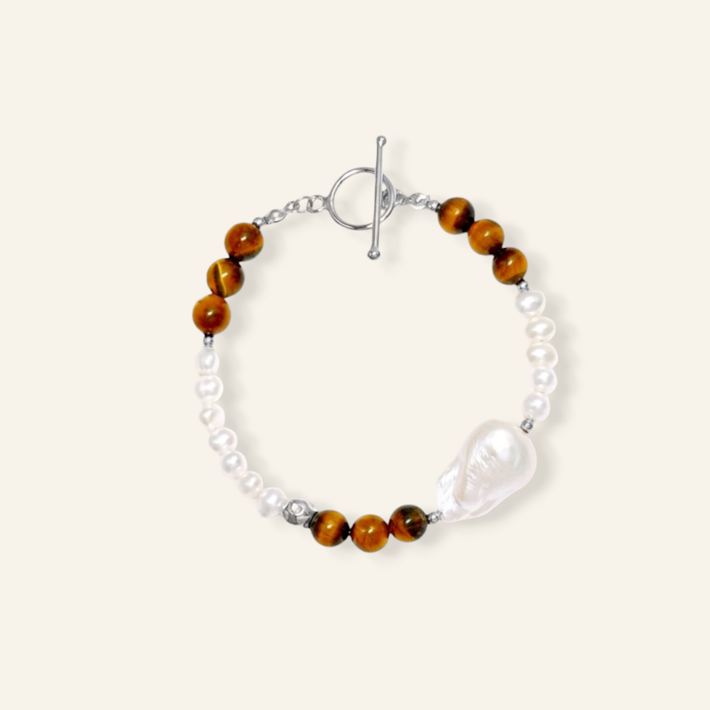 A bracelet featuring brown tiger's eye beads, white freshwater pearls, a large baroque pearl pendant, and silver metal 