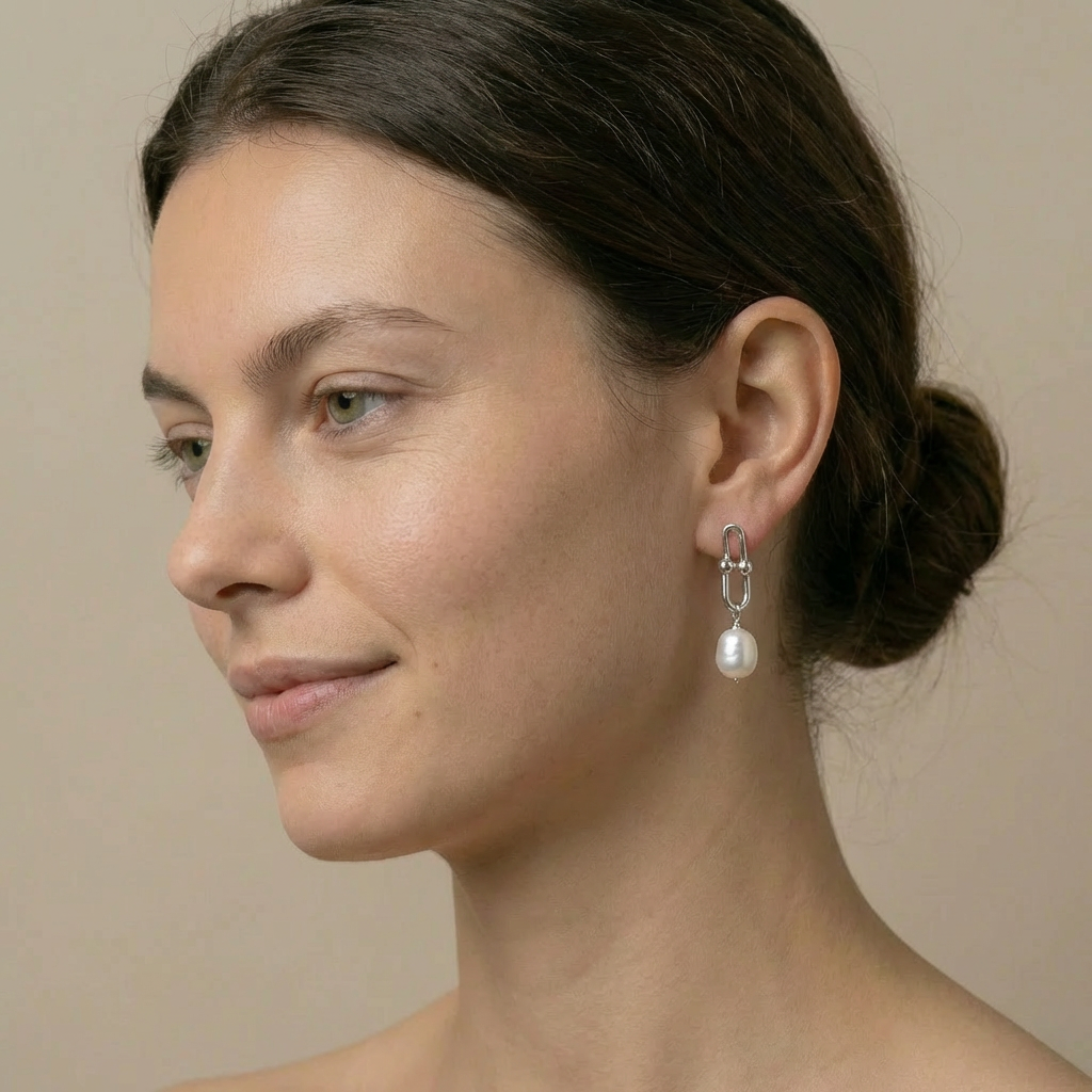 Woman wearing pearl earrings with a neutral background