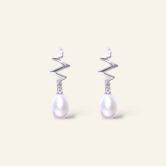 Pair of earrings with zigzag designs and pearl drops on a light background