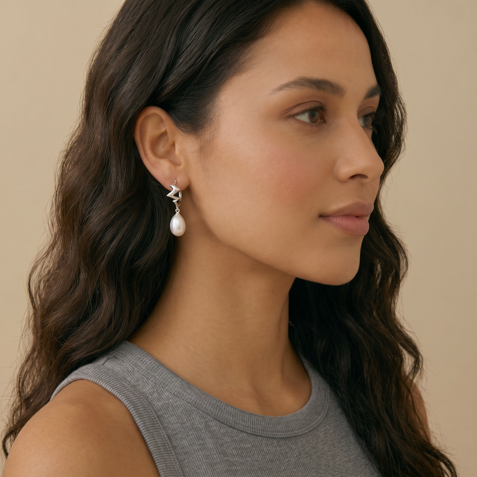 Woman wearing a pair of earrings with pearl
