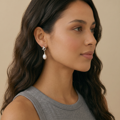 Woman wearing a pair of earrings with pearl
