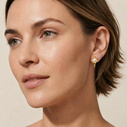 Close-up of a woman wearing a gold earring with a pearl 