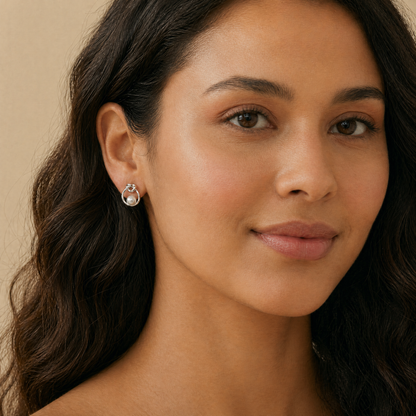 Close-up of a woman wearing pearl earrings against a neutral background
