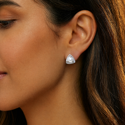 Close-up of a woman wearing a silver earring with a pearl center.