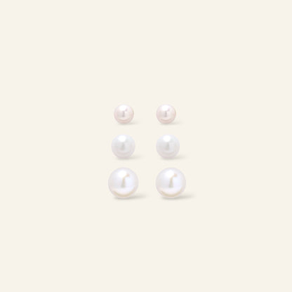 Set of pearl earrings on a light beige background