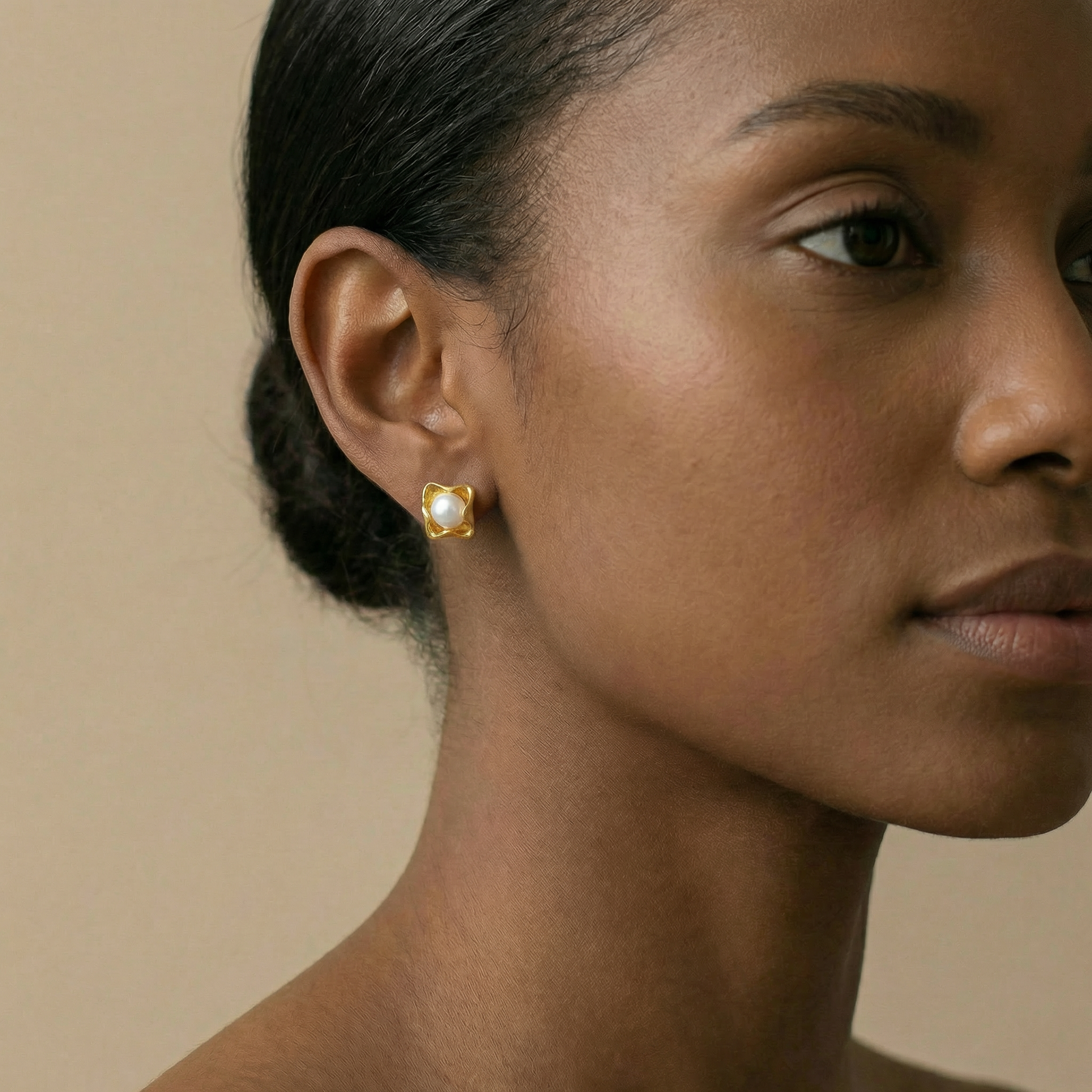 Close-up of a woman wearing a gold earring 