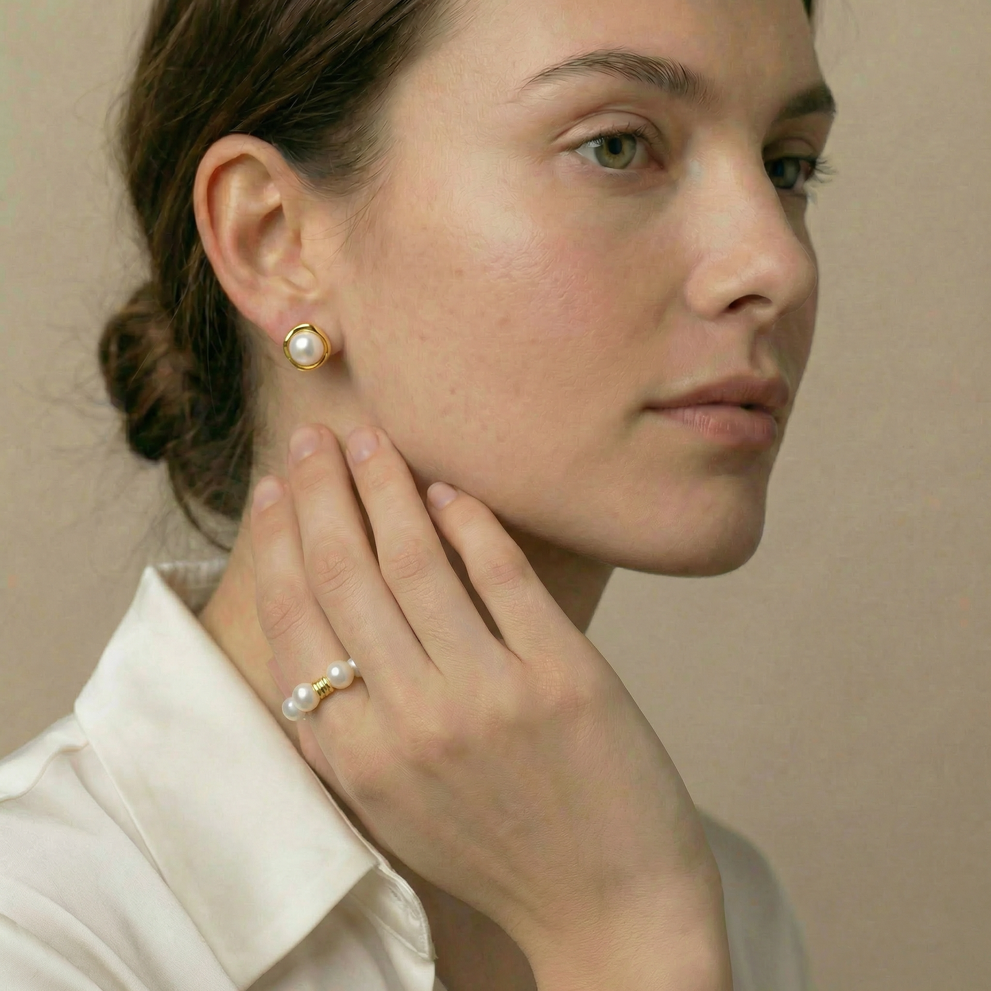 Woman wearing pearl earrings and ring