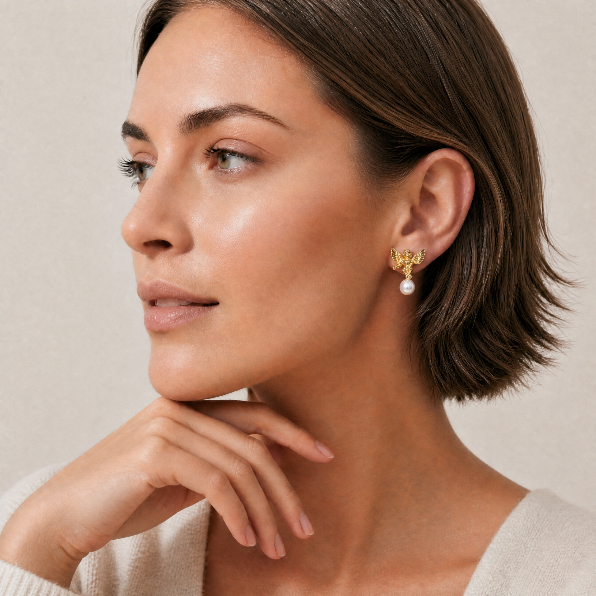 Woman wearing gold earrings with a pearl