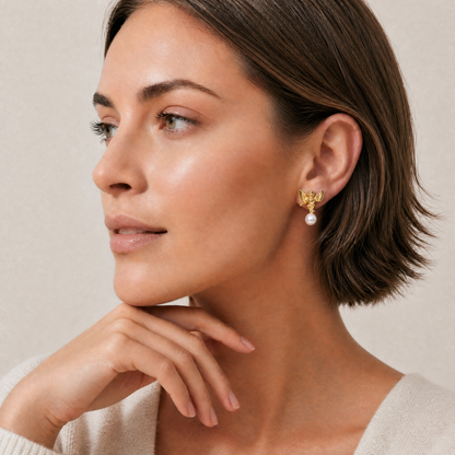 Woman wearing gold earrings with a pearl