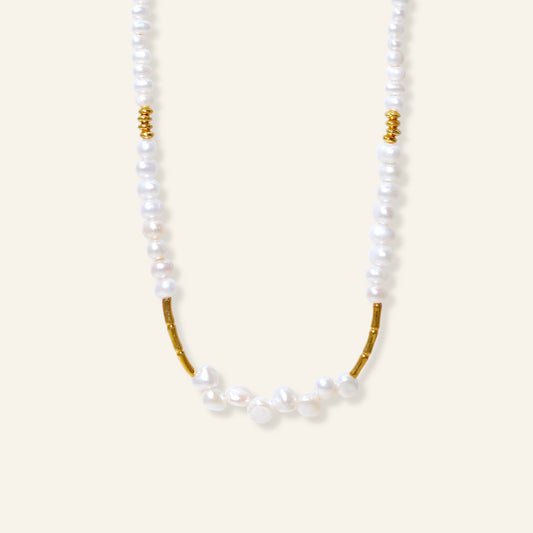 Pearl necklace with gold accents on a white background