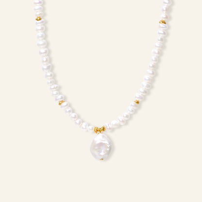 Pearl necklace with gold accents on a white background