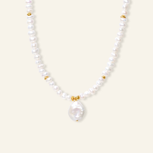 Pearl necklace with gold accents on a white background