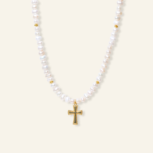 Pearl necklace with a gold cross pendant on a white background