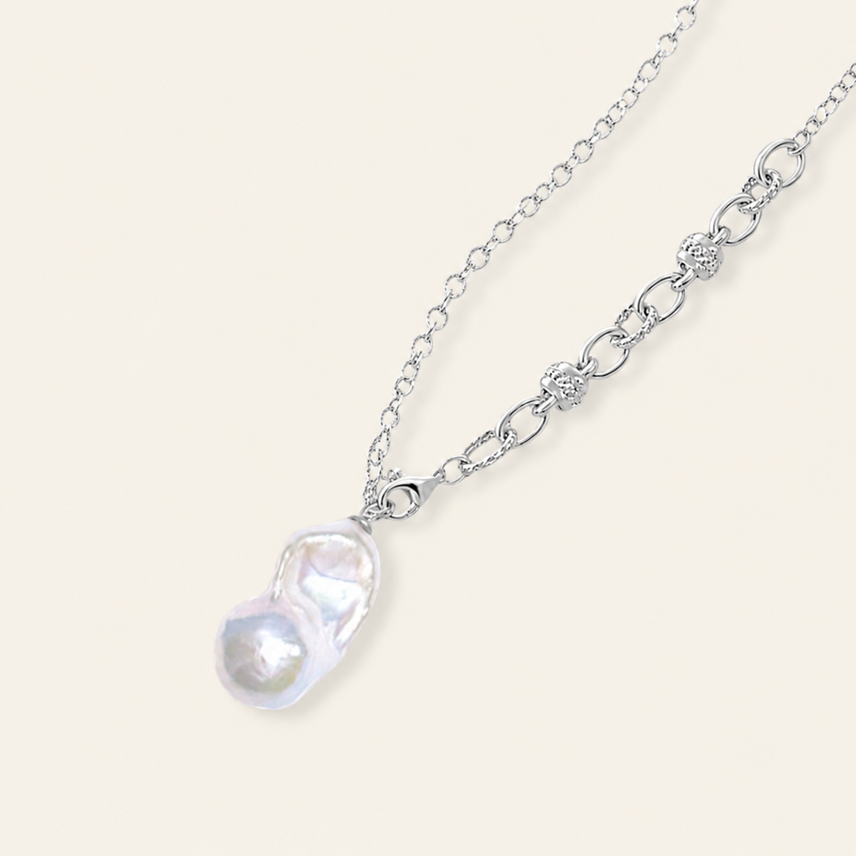 A silver chain necklace featuring a unique, organic-shaped baroque pearl pendant 