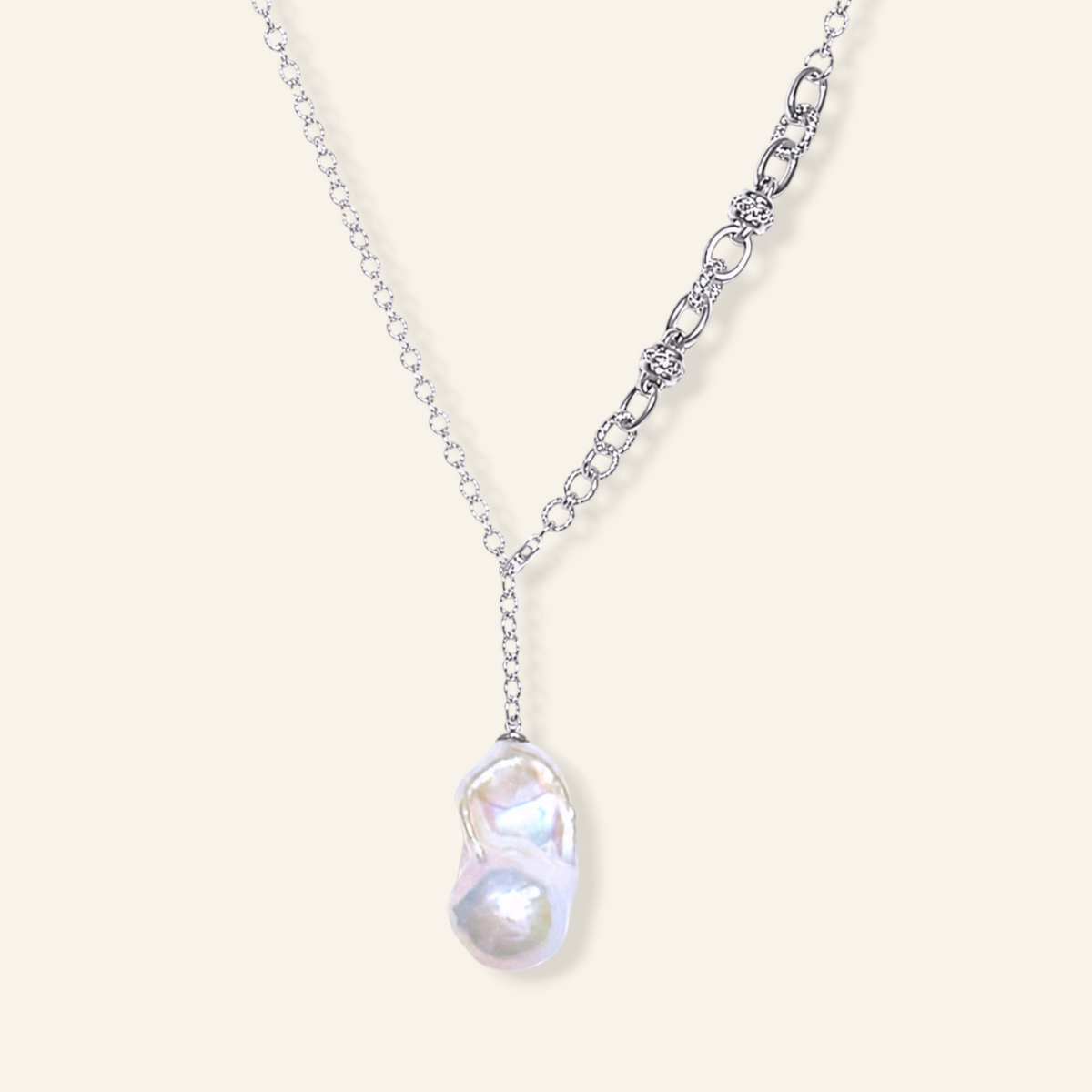 A silver-toned necklace featuring a large, irregular baroque pearl pendant 