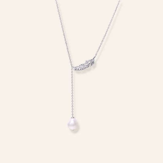 Freshwater pearl pendant necklace with a delicate feather-inspired metal detail and a single white pearl on a fine chain.