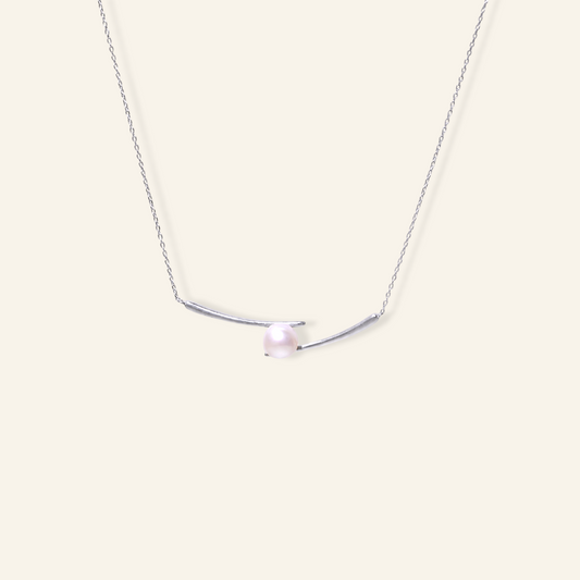 Gold freshwater pearl necklace with a single round white pearl set between two curved 18K gold plated bar details on a fine chain.