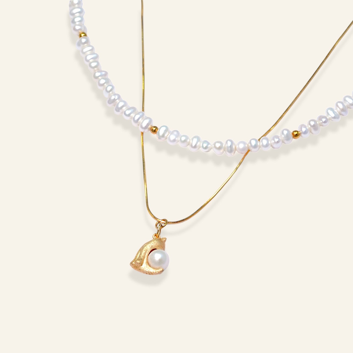 Two pearl necklaces with gold pendants 