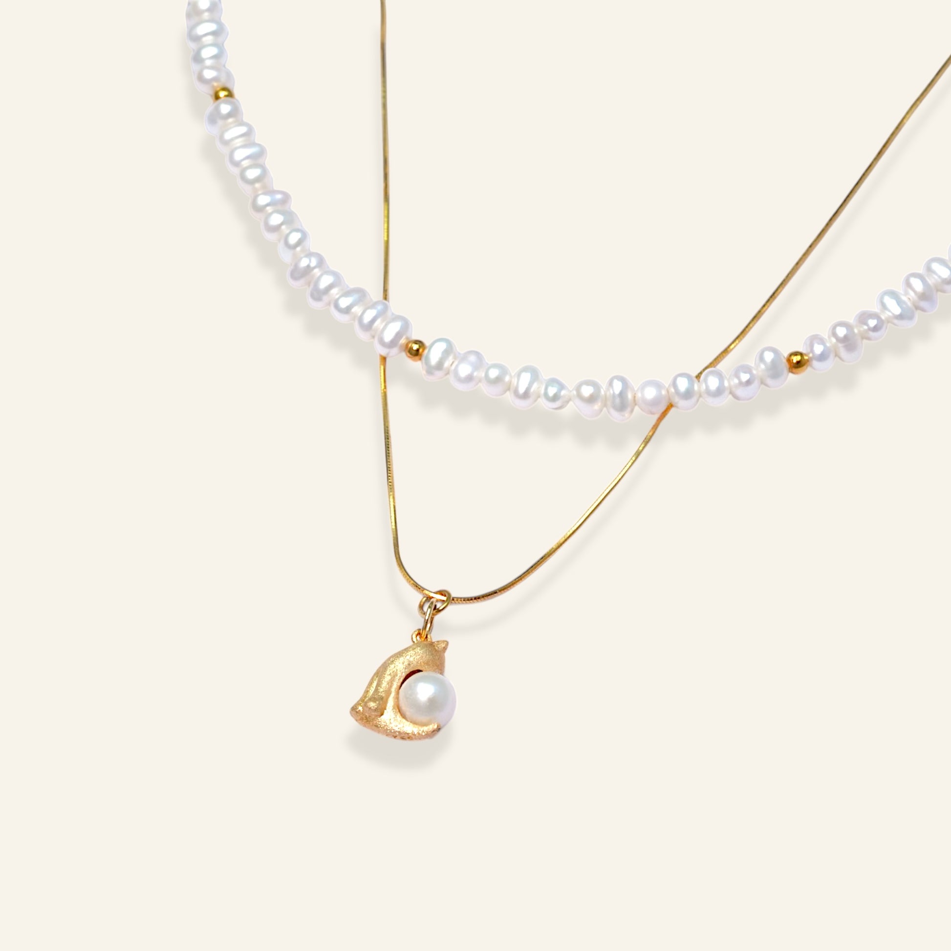 Two pearl necklaces with gold pendants 