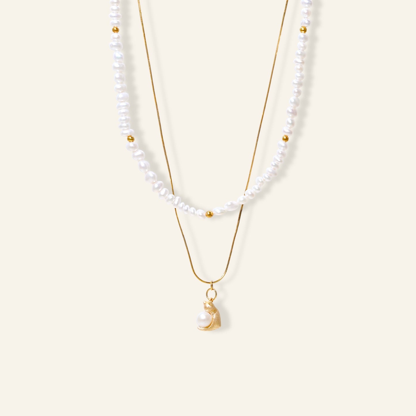 Two pearl necklaces with gold chains on a white background