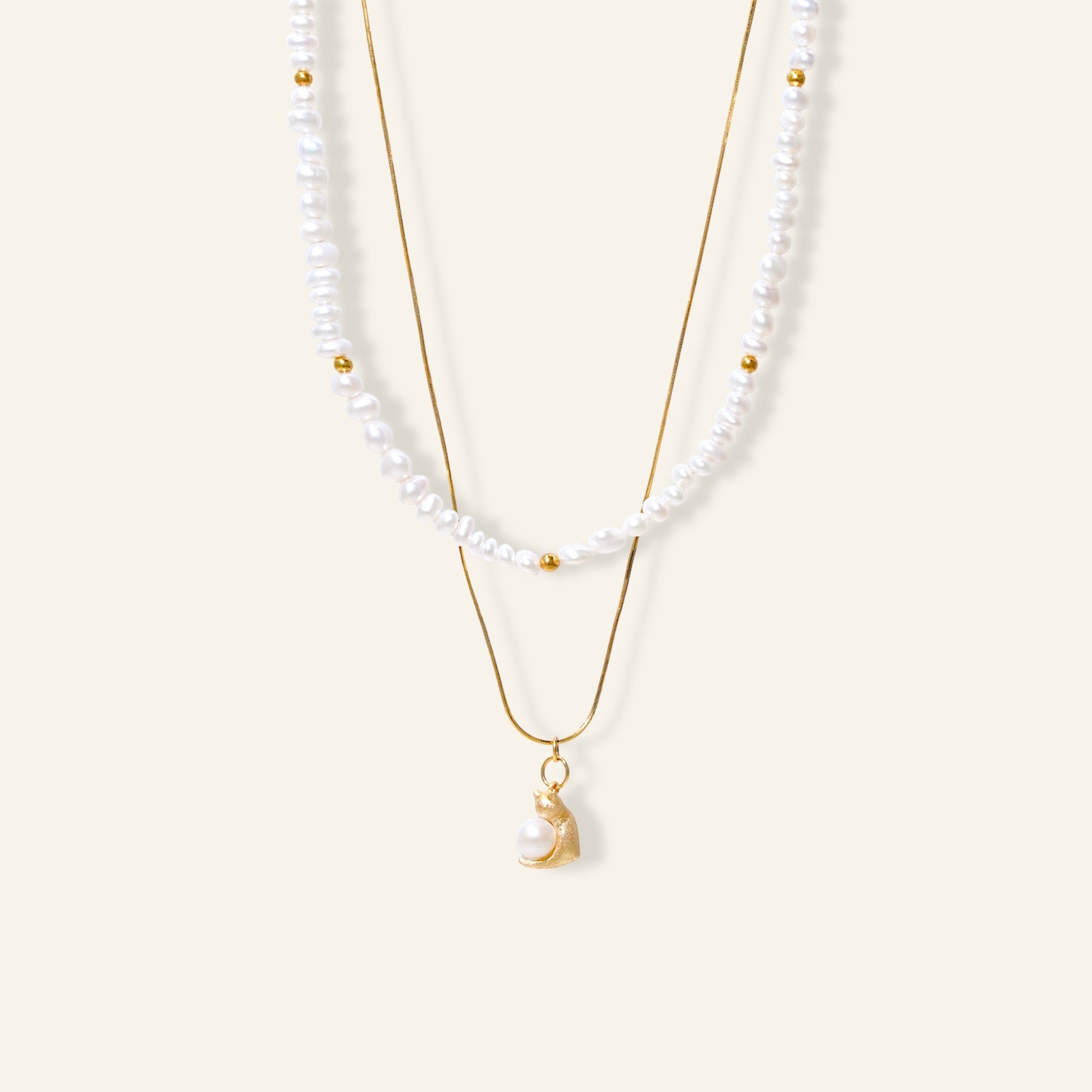 Two pearl necklaces with gold chains on a white background