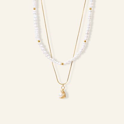Two pearl necklaces with gold chains on a white background