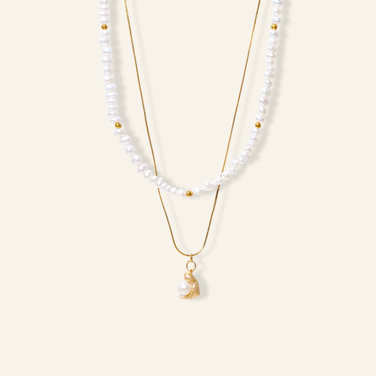Two pearl necklaces with gold chains on a white background
