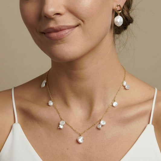 Woman wearing a gold necklace with pearl pendants 