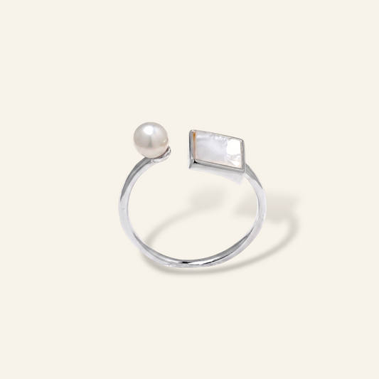 Silver ring with a pearl and rectangular gemstone on a white background