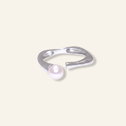 Silver ring with a pearl on a light gray background