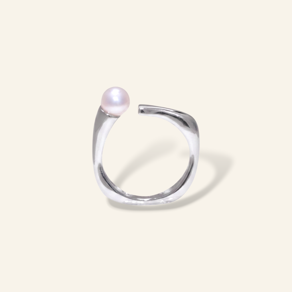Silver ring with a pearl on a light gray background