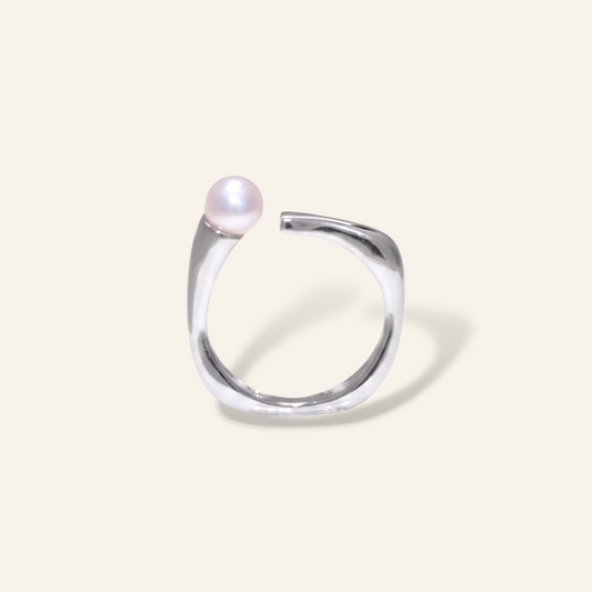 Silver ring with a pearl on a light gray background