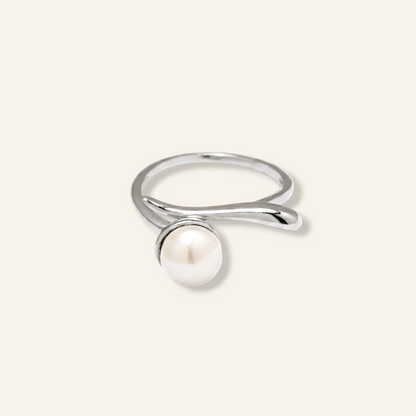 Silver ring with a pearl on a light gray background