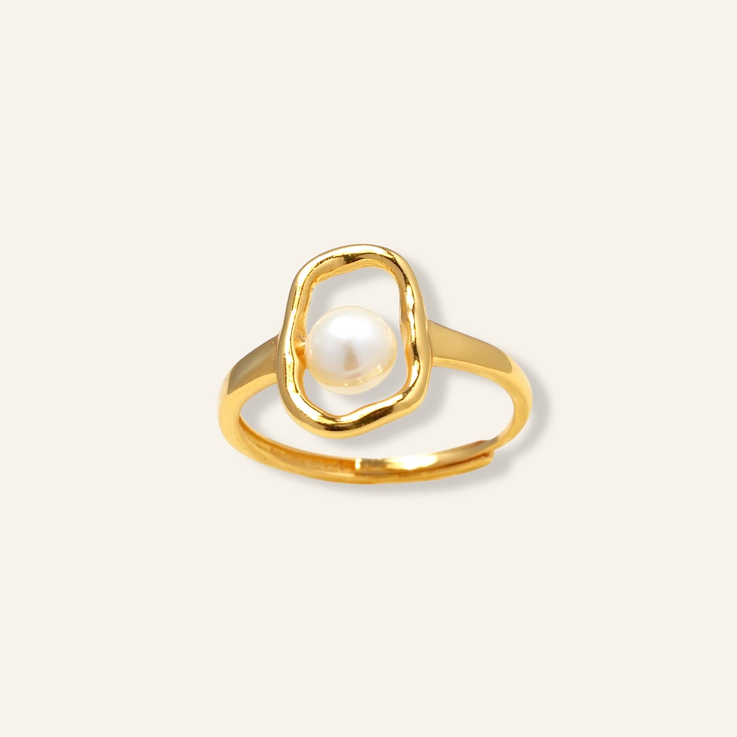 Gold ring with a pearl on a light beige background