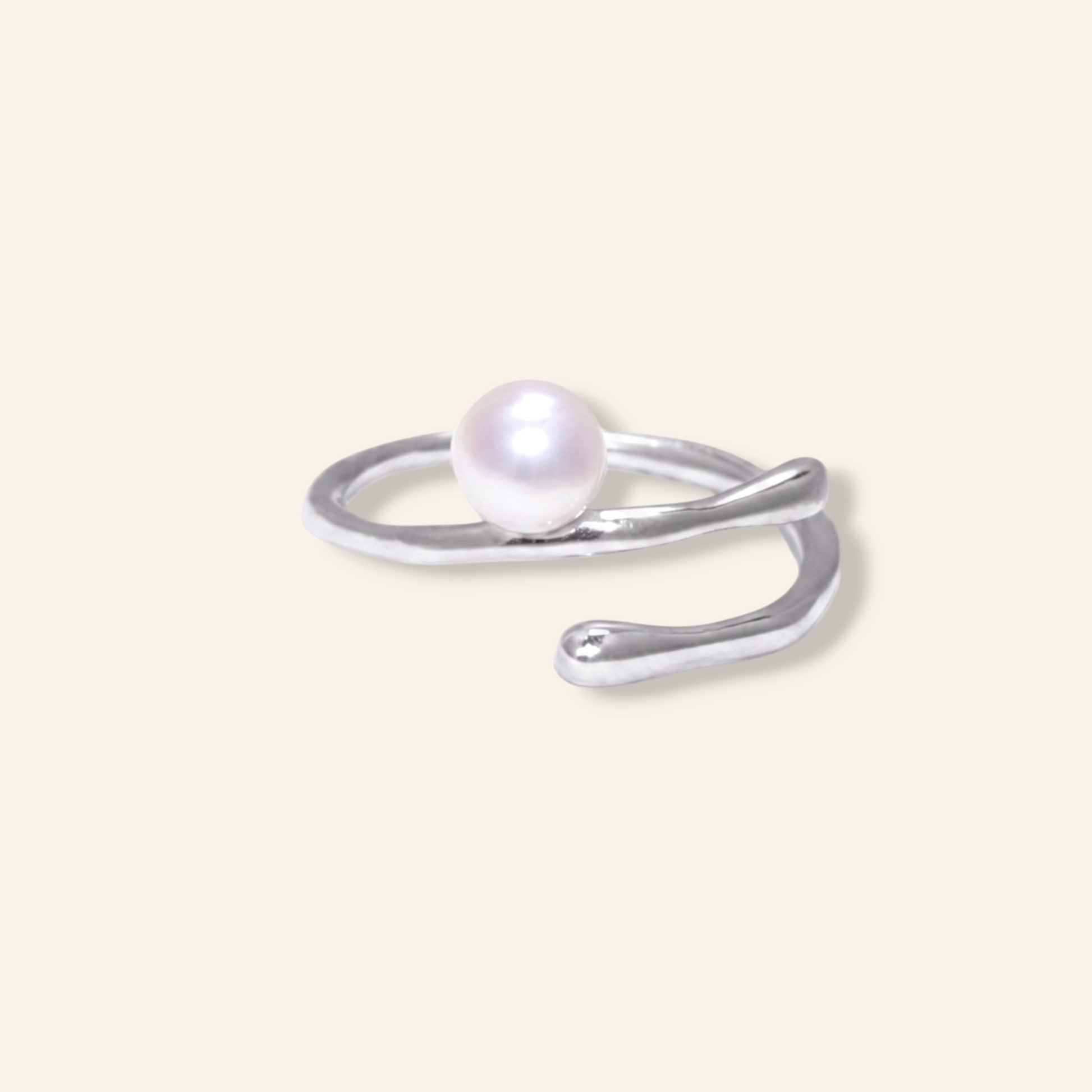 Silver ring with a pearl on a light beige background